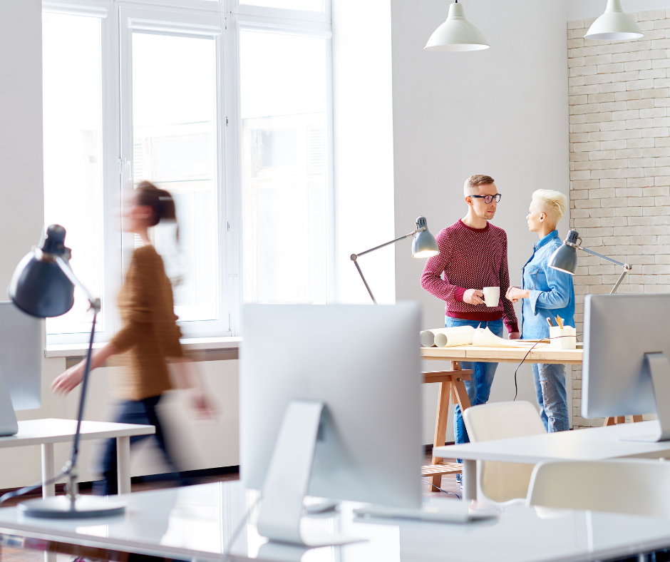 business team of designer drinking coffee and discussing restructures and how to manage change, while their colleague crossing office